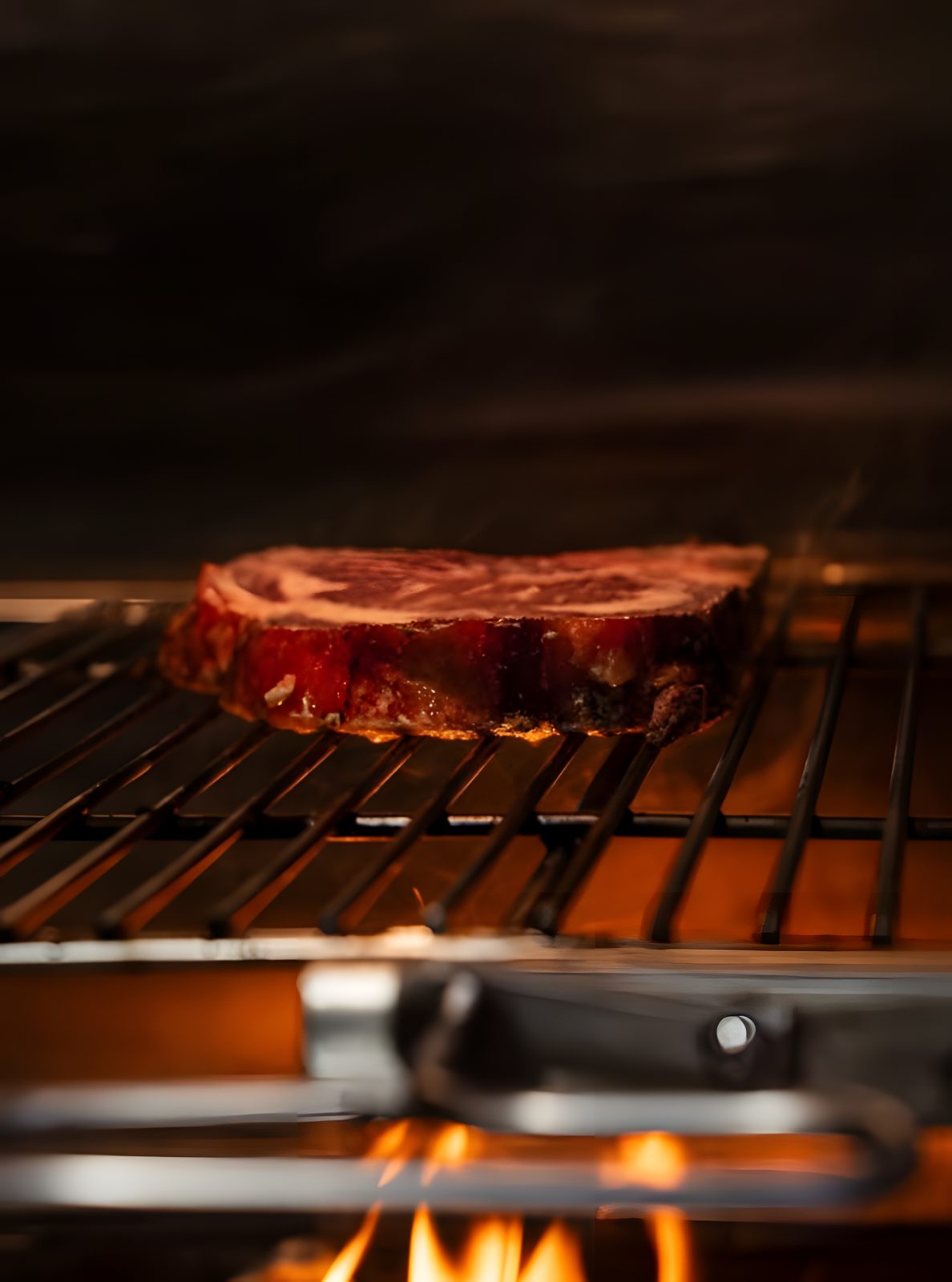 Bistecca sulla griglia, fiamme sotto